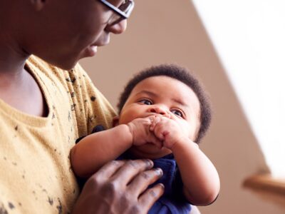 Loving Father Holding Newborn Baby At Home In Loft Apartment